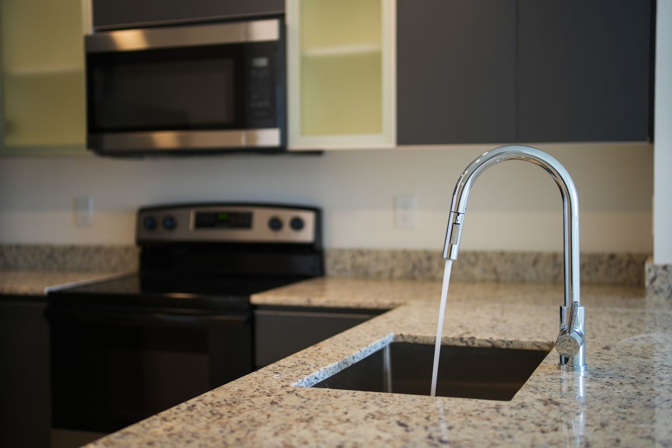 Baked grime on stovetop showing heat-bonded residue that cannot be removed by standard detergents